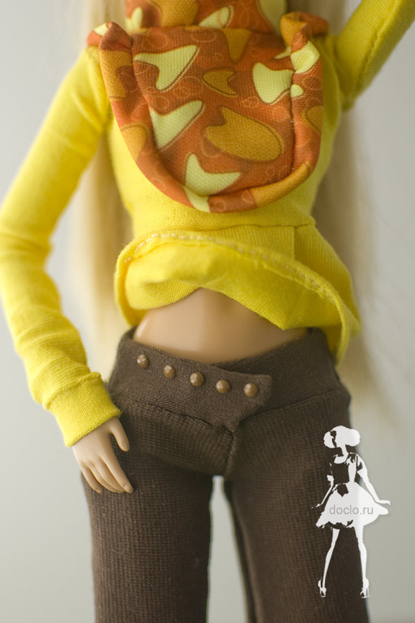 Увеличенная фотография куклы барби в блузе с рюшами и брюках, пояс с бусинами