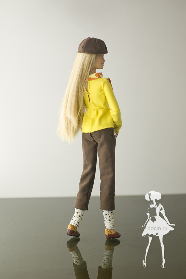 Фотография куклы барби сзади в блузе с рюшами, брюках с подворотом и берете, вид на пуговицы из бисера